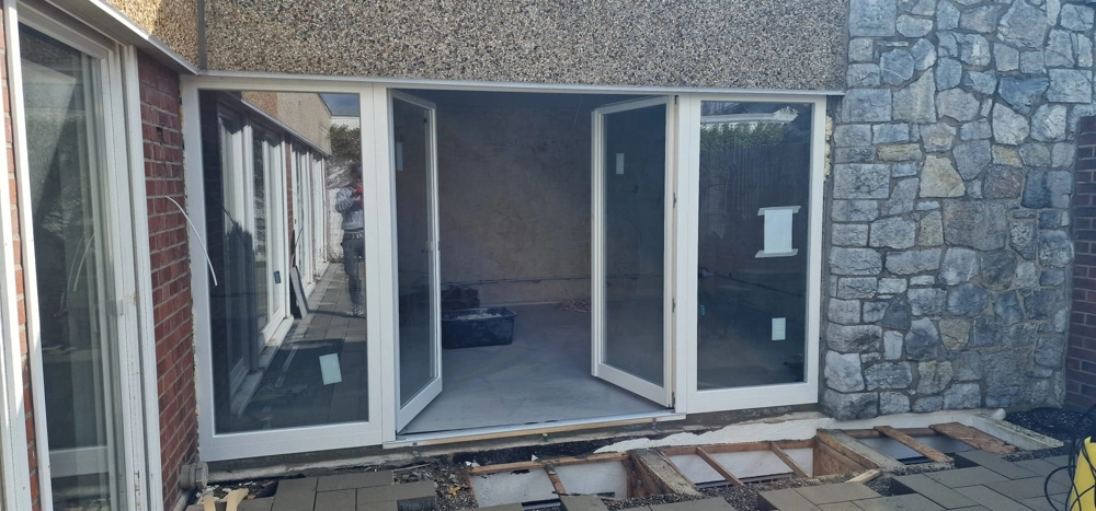 Weiße Kunststoff Haustüren in offener Rohbausituation vor Stein- und Putzfassade