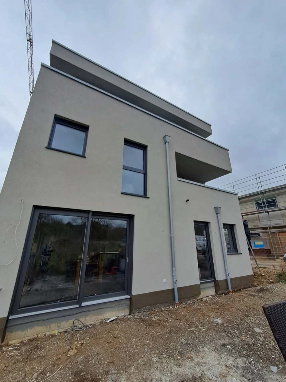 Neubaufassade mit glattem Außenputz und großen Fensterelementen
