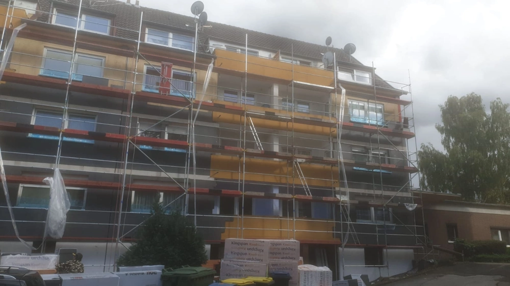 Mehrstöckiges Wohnhaus mit Gerüst und Anbringung von Dämmplatten im Rahmen der Wärmedämmung