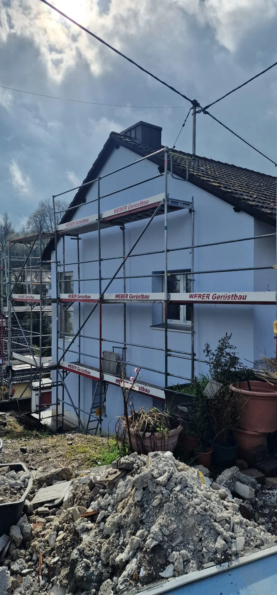 Hausfassade mit Gerüst und frischem Fassadenanstrich in hellem Blau