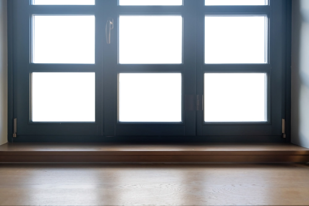 Innenansicht eines modernen Aluminiumfensters mit breiter Holzfensterbank und klarem Glas