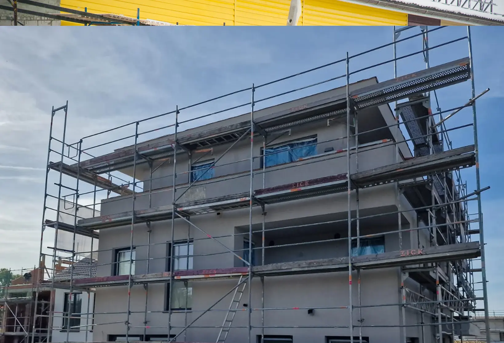 Mehrstöckiges Wohnhaus mit Gerüst für Fassadensanierung und Außenputzarbeiten