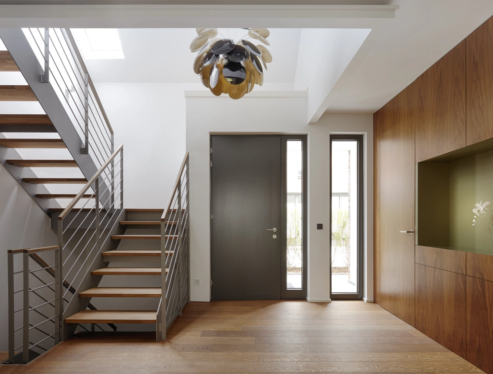 Modernes Entrée mit Aluminium Haustür, schmalem Seitenfenster, Treppe mit Holzstufen und Holzverkleidung